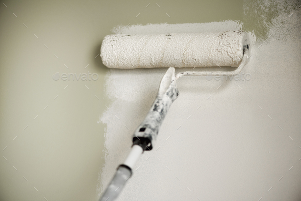 Hand painting wall with paint roller, pastel color. Appartment renovation, repair, building and home - Stock Photo - Images