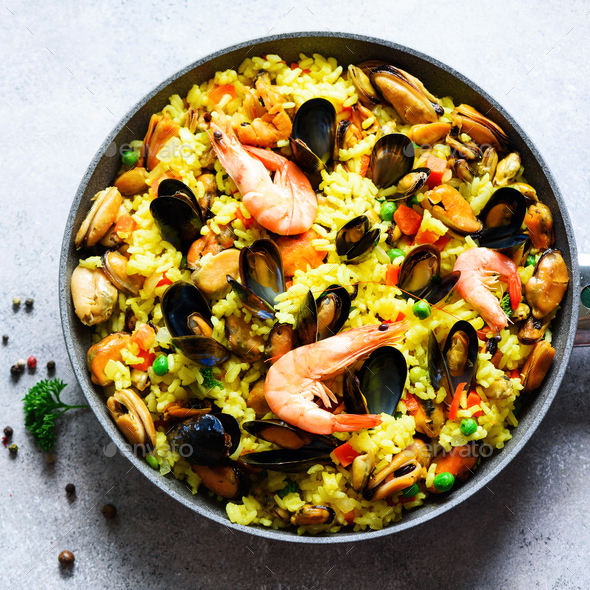 Traditional spanish seafood paella in pan rice, peas, shrimps, mussels