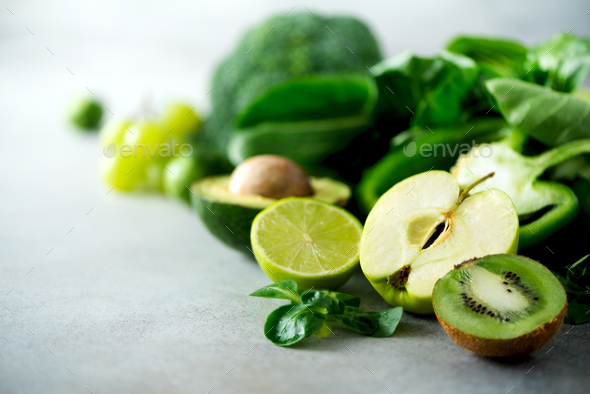 Organic green vegetables and fruits on grey background. Copy space. Green apple, lettuce, cucumber - Stock Photo - Images