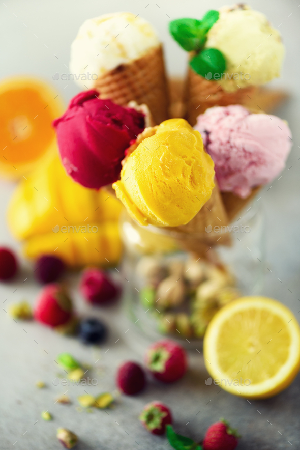Colorful ice cream balls in waffle cones with different flavors - mango, lime, mint, pistachio - Stock Photo - Images