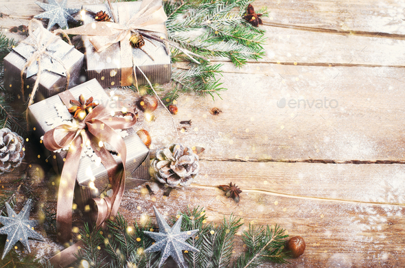 Gift boxes on old wooden background with silver stars, cones, hazelnut, anise, tape, ribbon - Stock Photo - Images