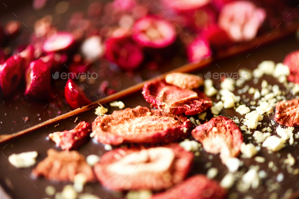 Handmade chocolate bars with dried cranberries, raspberries and pistachios, strawberries, nuts. Dark - Stock Photo - Images