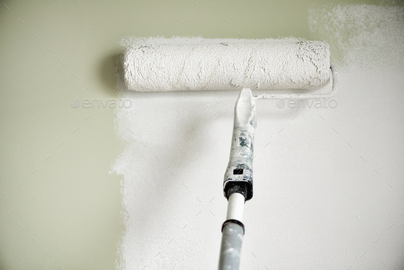 Hand painting wall with paint roller, pastel color. Appartment renovation, repair, building and home - Stock Photo - Images