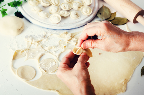 Traditional russian pelmeni, ravioli, dumplings with meat on white concrete background. Parsley - Stock Photo - Images