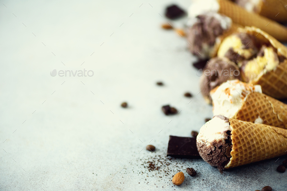 Chocolate and coffee ice cream in waffle cone with coffee beans on grey stone background. Summer - Stock Photo - Images