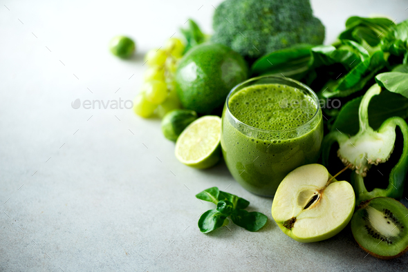 Glass with green health smoothie, kale leaves, lime, apple, kiwi, grapes, banana, avocado, lettuce - Stock Photo - Images