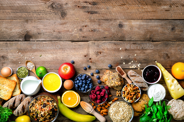 Healthy breakfast ingredients, food frame. Granola, egg, nuts, fruits, berries, toast, milk, yogurt - Stock Photo - Images