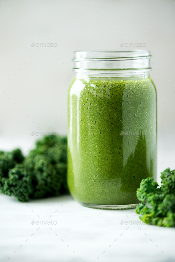 Glass jar mugs with green health smoothie, kale leaves, lime, apple, kiwi, grapes, banana, avocado - Stock Photo - Images