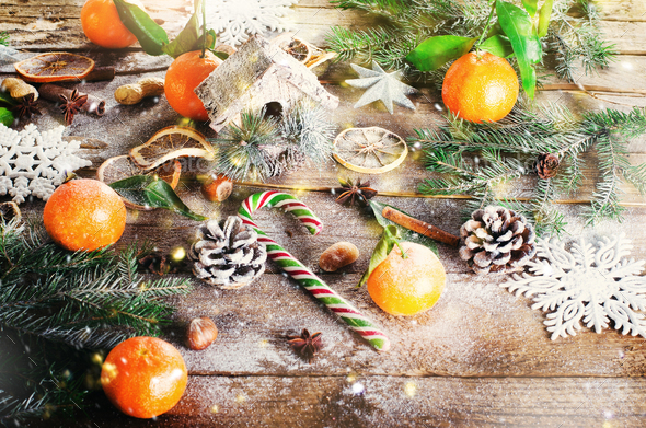 Magic Christmas background - vintage wood, candy cane, house, cinnamon, star anise, sweet mandarins - Stock Photo - Images