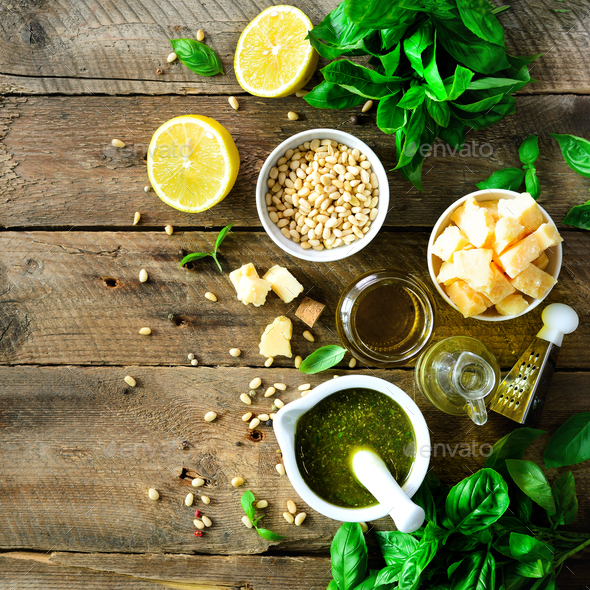 Ingredients for homemade pesto - basil, lemon, parmesan, pine nuts, garlic, olive oil and salt on - Stock Photo - Images