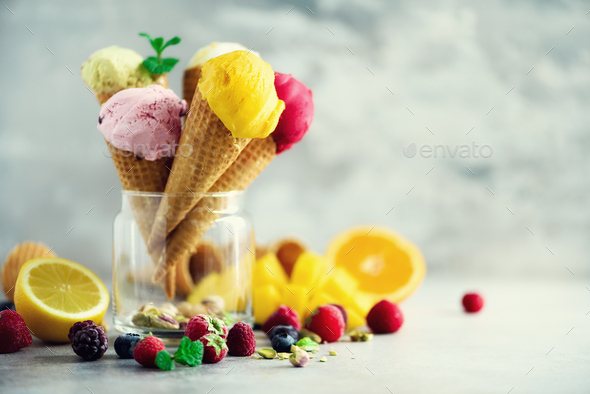 Colorful ice cream balls in waffle cones with different flavors - mango, lime, mint, pistachio - Stock Photo - Images