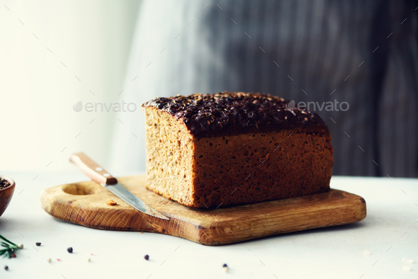 Woman hands slicing freshly backed bread. Handmade brown loaf of bread, bakery concept, homemade - Stock Photo - Images