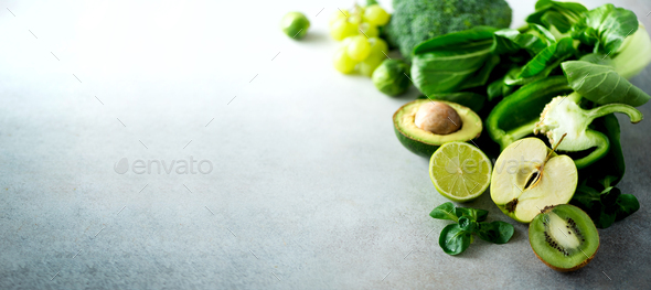 Organic green vegetables and fruits on grey background. Copy space. Green apple, lettuce, cucumber - Stock Photo - Images