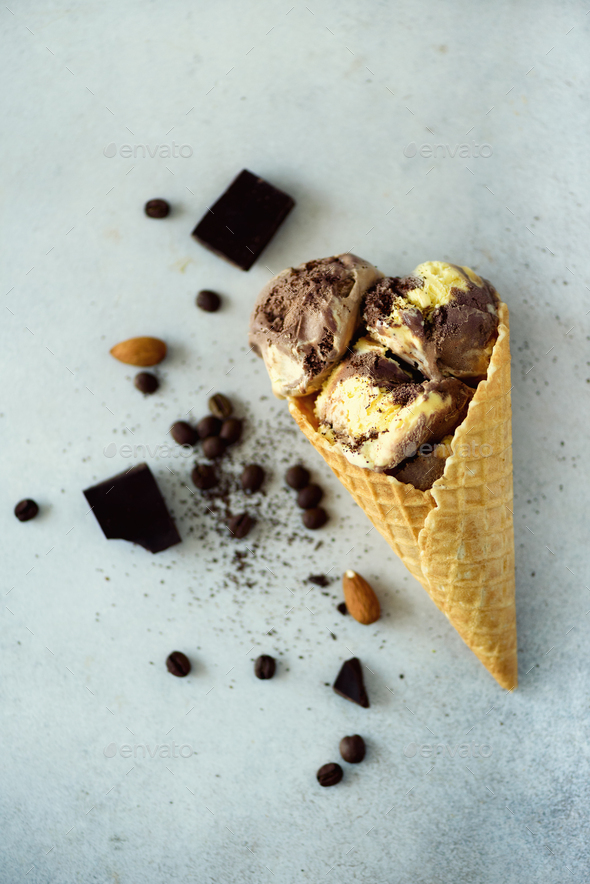 Chocolate, vanilla and coffee ice cream in waffle cone with coffee beans on grey stone background - Stock Photo - Images