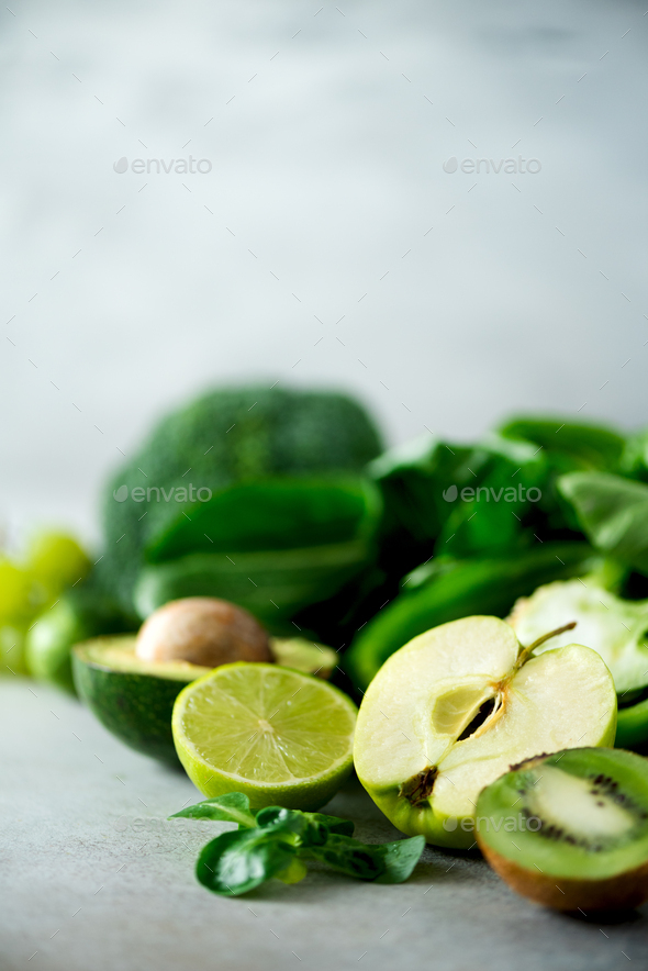 Organic green vegetables and fruits on grey background. Copy space. Green apple, lettuce, cucumber - Stock Photo - Images