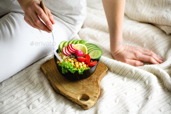 Girl holds in hands vegan, detox raw buddha bowl with avocado, quinoa, cucumber, radish, salad - Stock Photo - Images