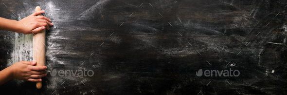 Girl hands keep rolling pin with flour on dark black table, baking background, top view, copy space - Stock Photo - Images