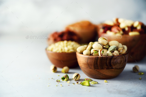 Pistachios nuts in wooden bowl. Food mix background, top view, copy space, banner. Assortment of - Stock Photo - Images