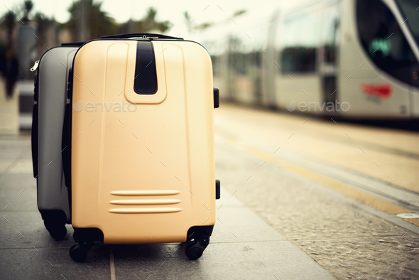 Two suitcases standing on railway station against city train. Vacation and travel concept. Citypass - Stock Photo - Images