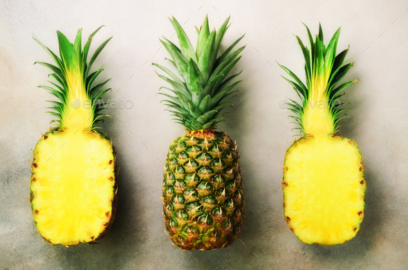 Half slice of fresh pineapple and whole fruit on gray background. Top View. Copy Space. Bright - Stock Photo - Images