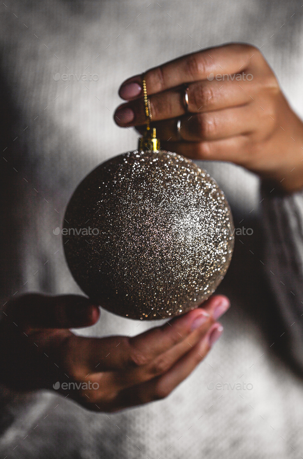 Woman in warm sweater holding toy glass decorative ball in hands, copy space. Christmas, new year - Stock Photo - Images