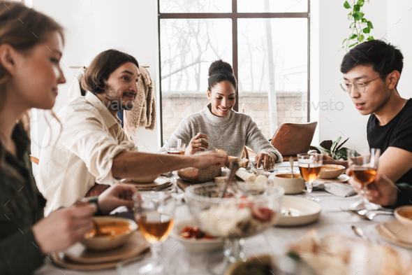 Young colleagues happily discussing work having lunch together - Stock Photo - Images