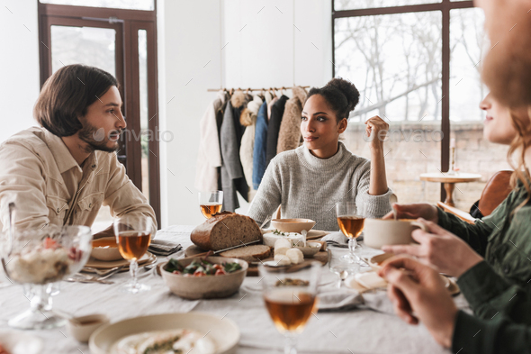 African american woman sitting at the table thoughtfully looking at man with beard - Stock Photo - Images