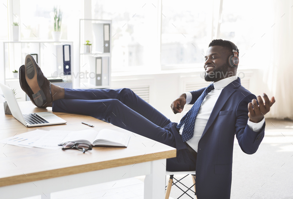 Young relaxed businessman having fun at office