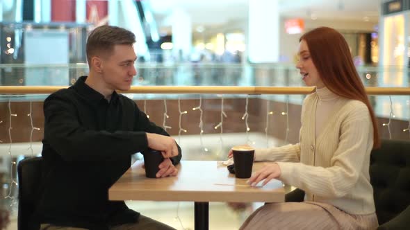 Side View of Handsome Young Man and Attractive Woman Having Fun Conversation Sitting at Table in alt