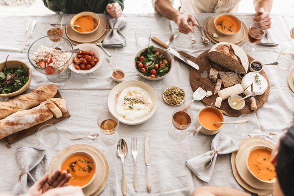 Close up fresh bread with cheese and bowls with pumpkin soups on lunch in cozy cafe - Stock Photo - Images