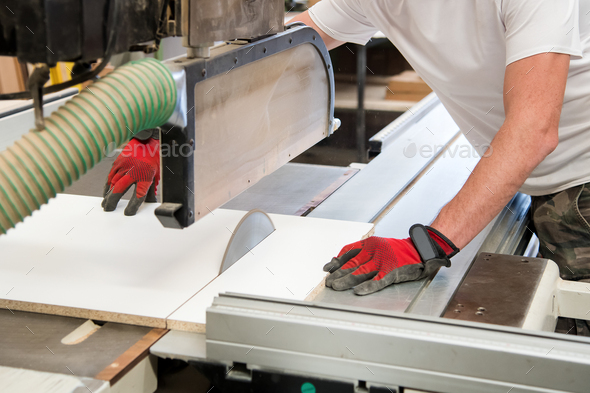Carpenter or joiner cutting a wooden board - Stock Photo - Images