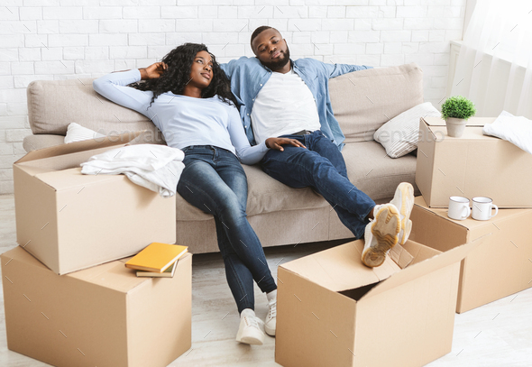 Couple On Couch Taking Break From Unpacking On Moving Day