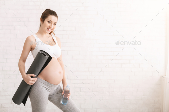Cheerful and healthy pregnant woman smiling after yoga training