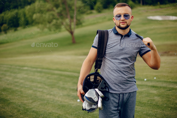 Handsome man playing golf on a golf course