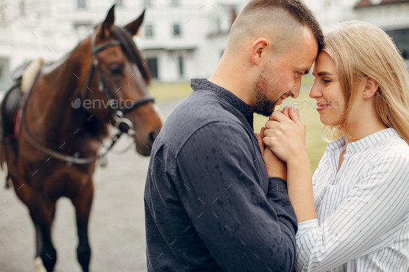 Cute loving couple with horse on ranch