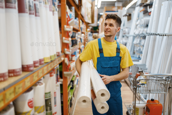 Builder with roll of wallpapers in hardware store