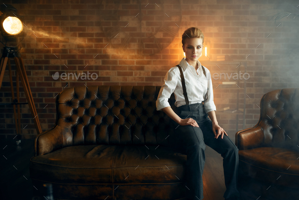 Business woman in strict clothes on leather couch
