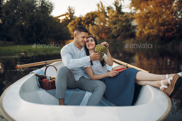 Love couple hugs in a boat on quiet lake - Stock Photo - Images