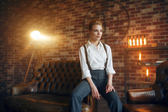 Business woman in strict clothes on leather couch - Stock Photo - Images