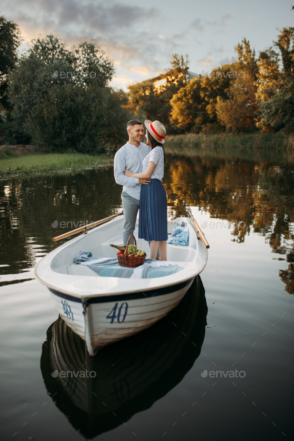 Love couple standing in a boat on quiet lake - Stock Photo - Images