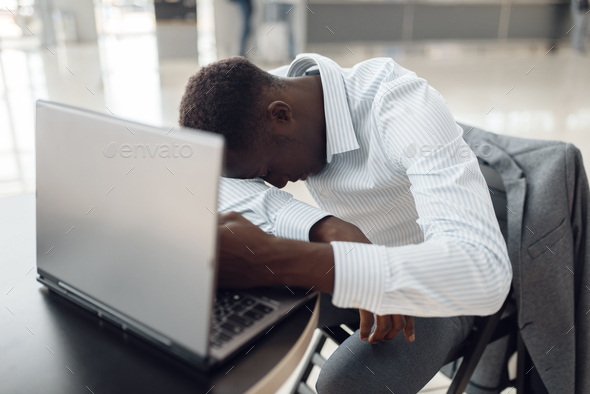 Businessman with laptop sleeping in office cafe - Stock Photo - Images