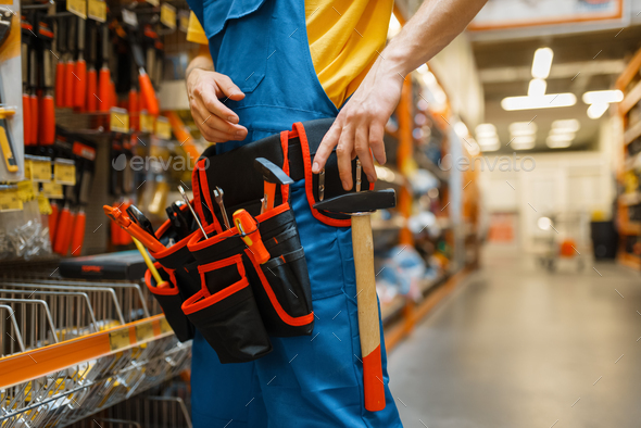 Male builder trying on tool belt in hardware store