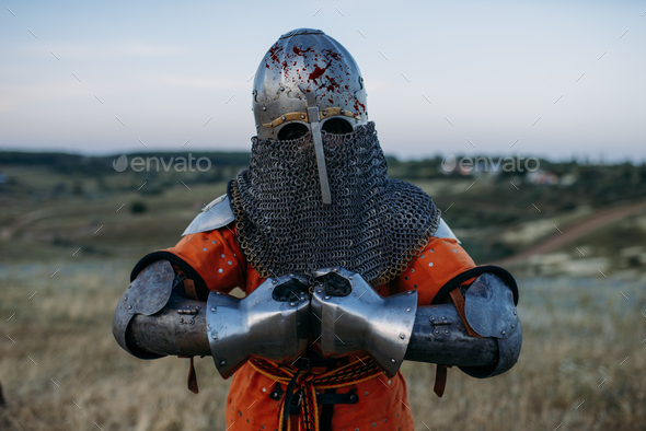 Medieval knight in metal armor holds sword