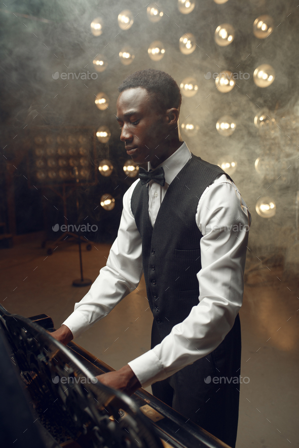 Black grand piano player playing on the stage - Stock Photo - Images