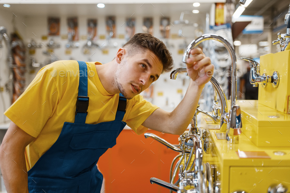 Male builder choosing water tap in hardware store