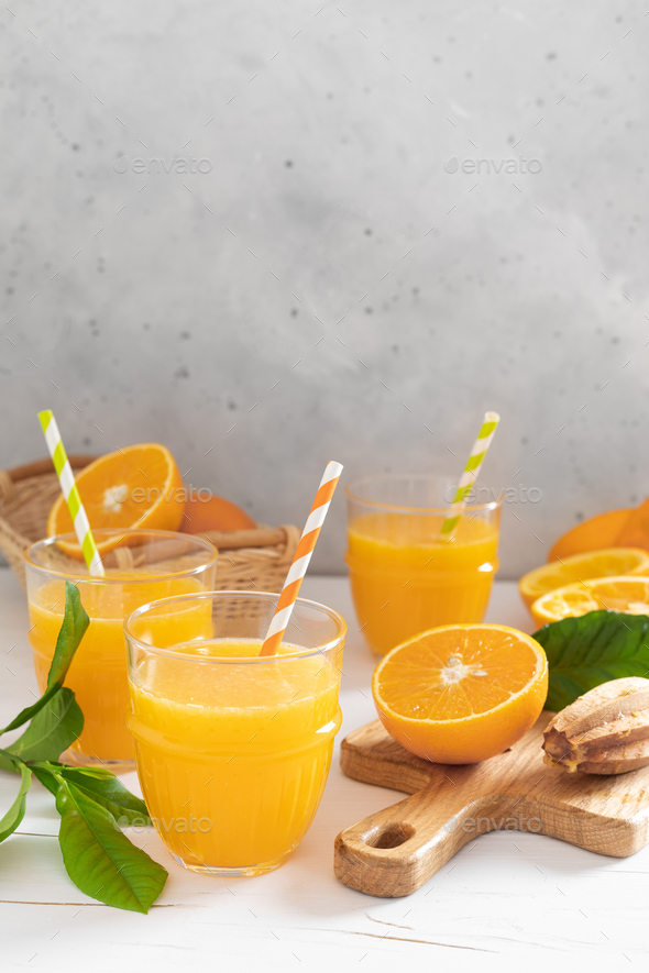 Orange juice. Freshly squeezed juice in glasses and fresh fruits with leaves
