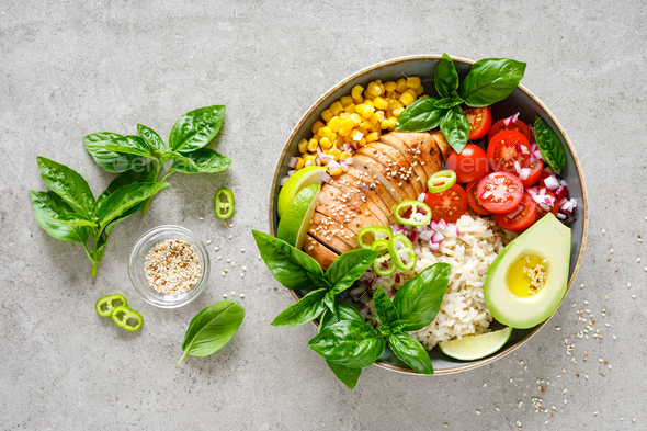 Buddha lunch bowl with grilled chicken breast, tomato, onion, corn, avocado, basil salad and rice - Stock Photo - Images