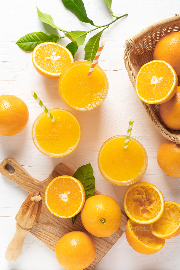 Orange juice. Freshly squeezed juice in glasses and fresh fruits with leaves, view from above