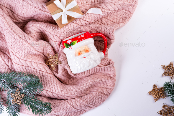 Pink knitted sweater with gift box, Santa's cup, christmas decoration and fir branches on a - Stock Photo - Images
