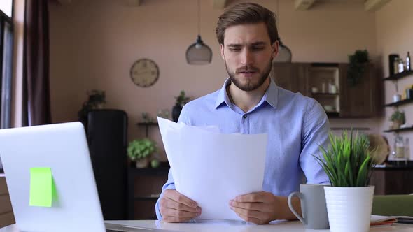 Worried, thoughtful, serious entrepreneur man working on laptop at home office alt
